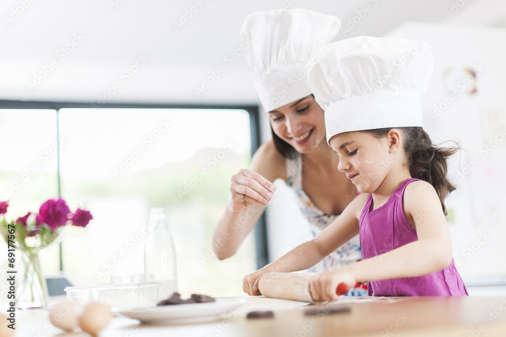 little girl helping her mother prepare a cake little girl helping her mother prepare a cake