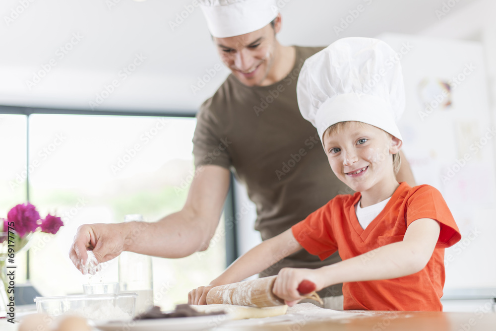 a father and his son preparing a cake in the kitchen a father and his son preparing a cake in the kitchen