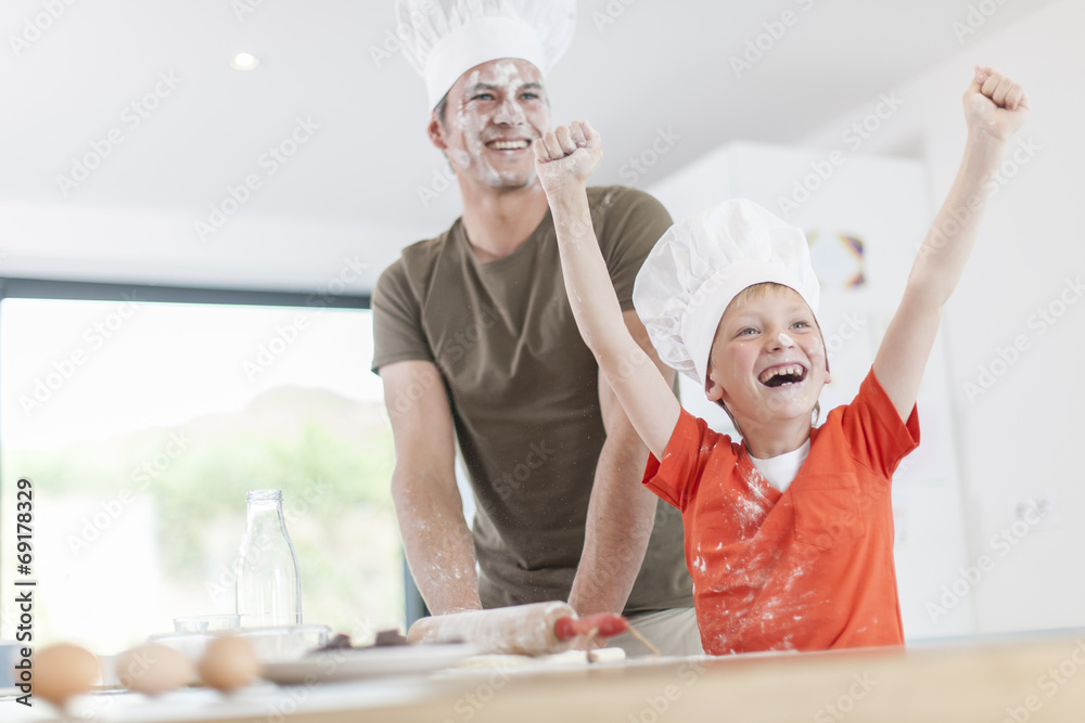 a father and his son preparing a cake in the kitchen a father and his son preparing a cake in the kitchen