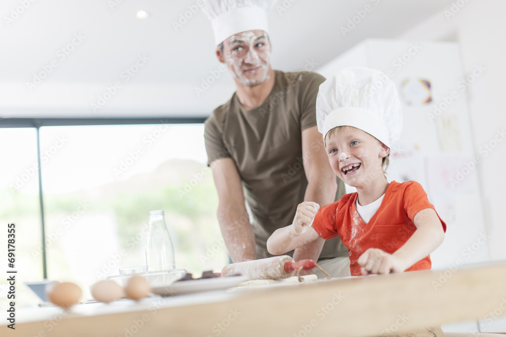 a father and his son preparing a cake in the kitchen a father and his son preparing a cake in the kitchen