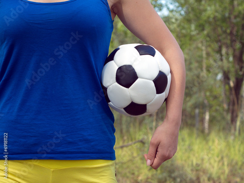 Girl holding a classical football sports ball for soccer © DyMaxFoto