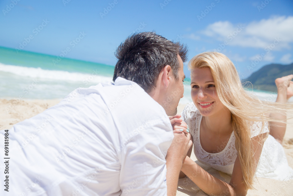 Cheerful couple lying on the beach on a sunny day Cheerful couple lying on the beach on a sunny day
