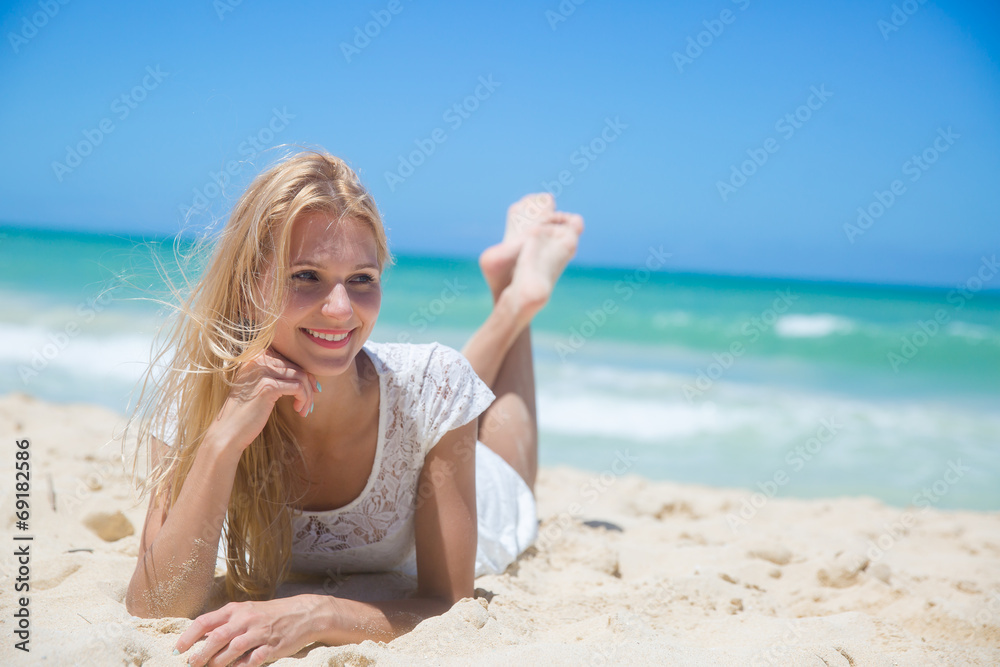 Smiling young girl lying on the sunny beach Smiling young girl lying on the sunny beach