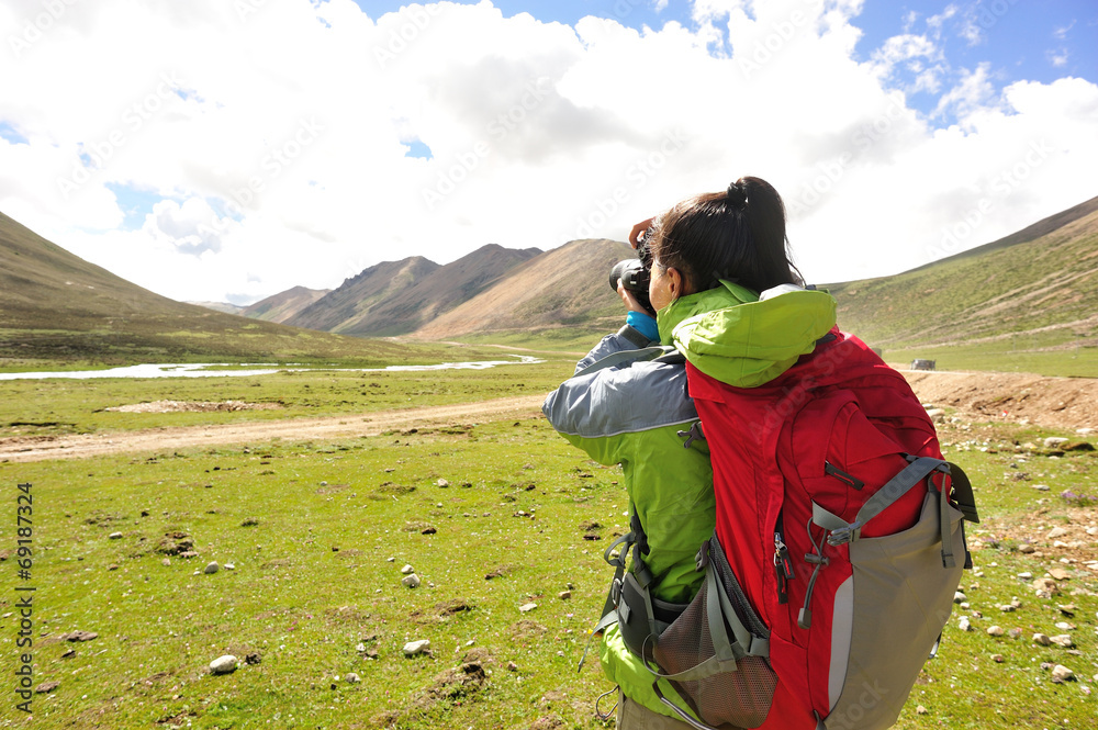 hiking woman taking photo in tibet,china
