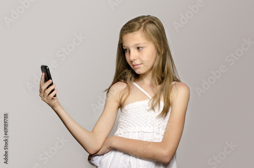 Young girl taking a selfie, kid taking a photo herself