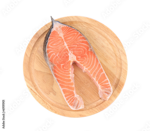 Raw salmon steak on cutting board.