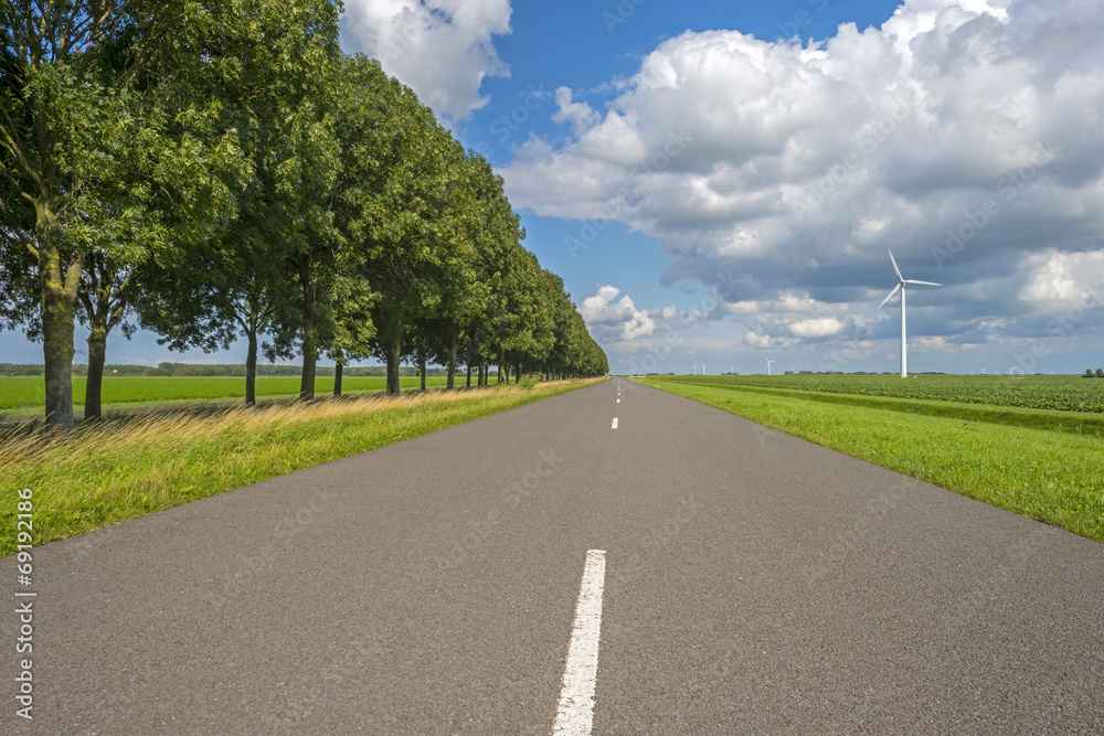 Fototapeta premium Clouds over a road through the countryside