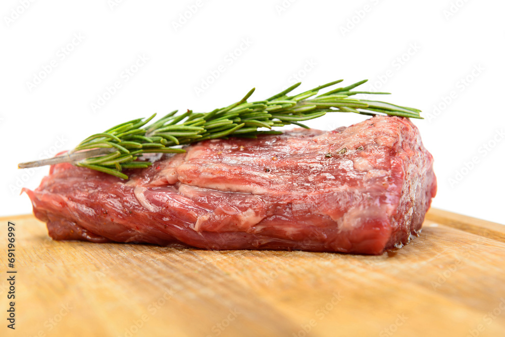 raw steak with rosemary on wood plate raw steak with rosemary on wood plate