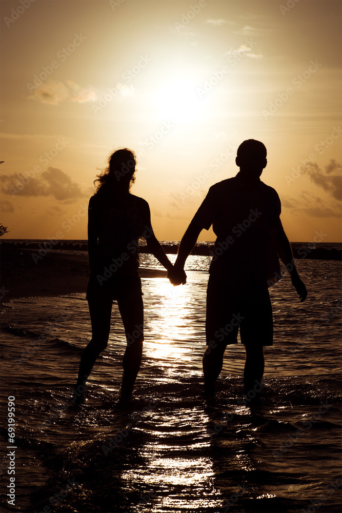 Silhouette of a young couple at sunset near the shore of the oce