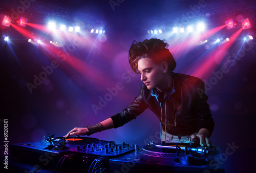 Teenager Dj mixing records in front of a crowd on stage