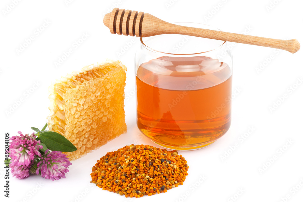 Honey in jar with dipper, honeycomb, pollen and flowers Honey in jar with dipper, honeycomb, pollen and flowers