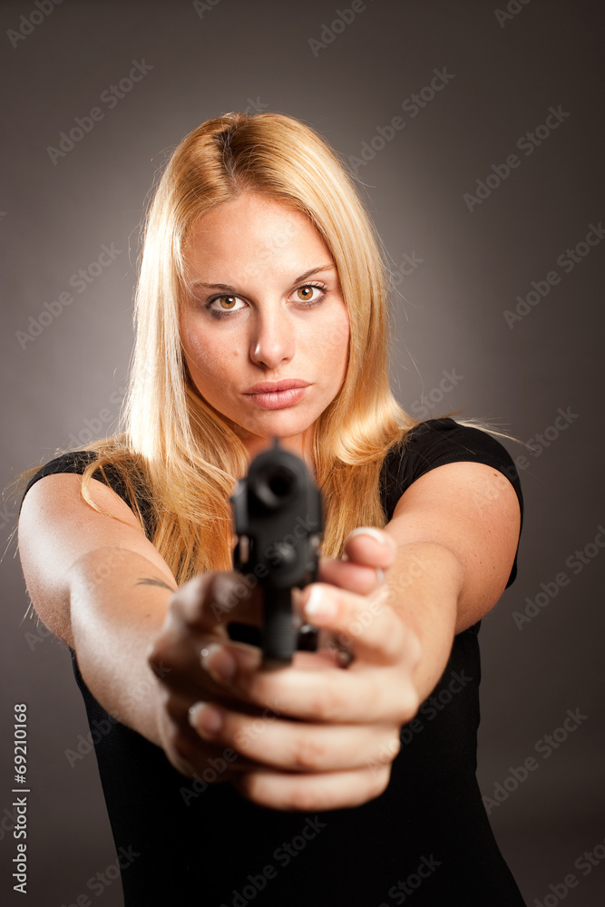 woman with a gun on gray background woman with a gun on gray background