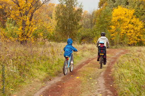 Active family on bikes, cycling in autumn park