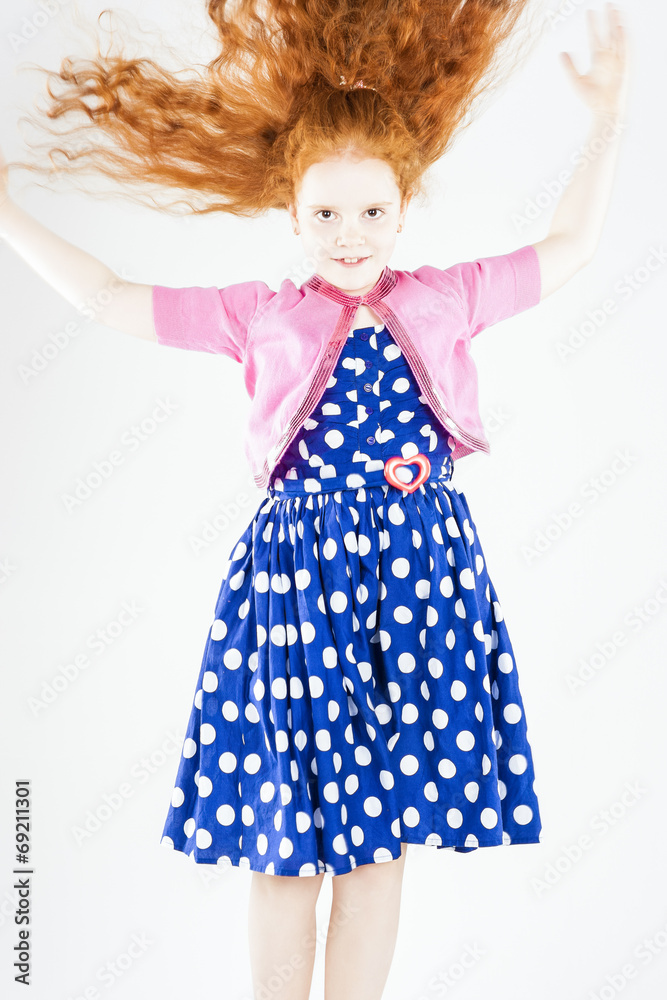 Happy Jumping Red-haired Caucasian Girl In Polka-Dotted Dress Pl
