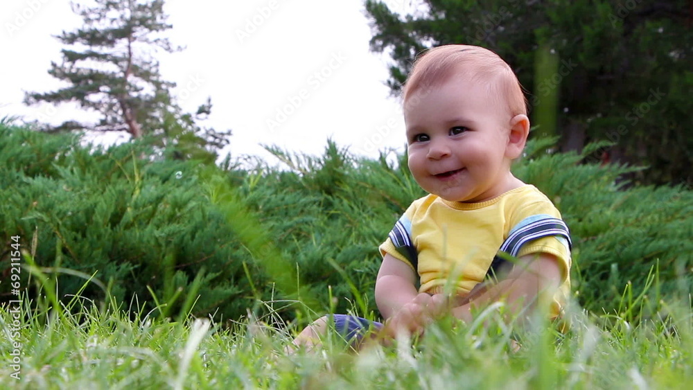 Cute baby boy having fun with soap bubbles on grass Cute baby boy having fun with soap bubbles on grass