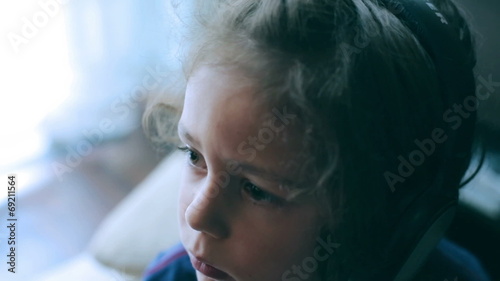 Young boy watching television and wearing headphones photo