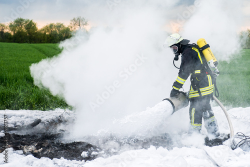 Feuerwehrmann bei Löscharbeiten mit Schaummittel