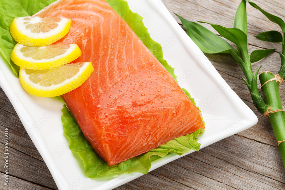 Fresh salmon fish with lemon and salad leaves Fresh salmon fish with lemon and salad leaves