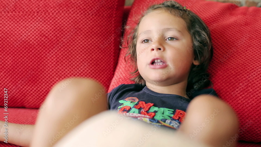 Boy playing with pillow and singing a song on the sofa Boy playing with pillow and singing a song on the sofa