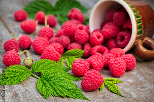 Red ripe raspberries on a wooden background