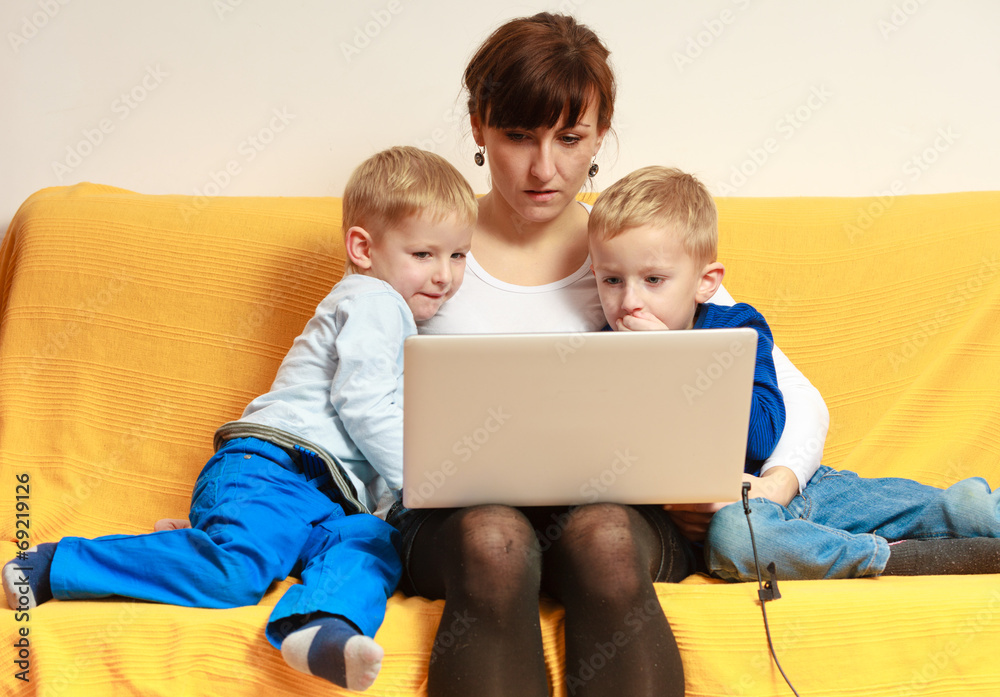 Happy family. Mother and sons using laptop Happy family. Mother and sons using laptop
