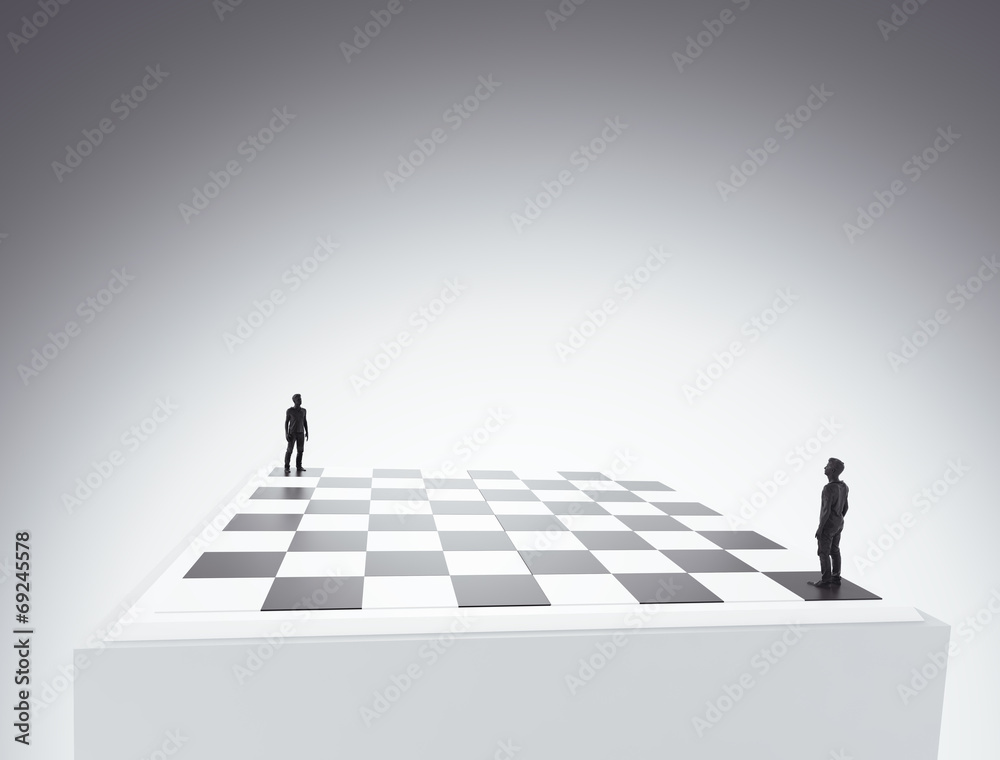 Two tiny figures standing on a chess board Two tiny figures standing on a chess board