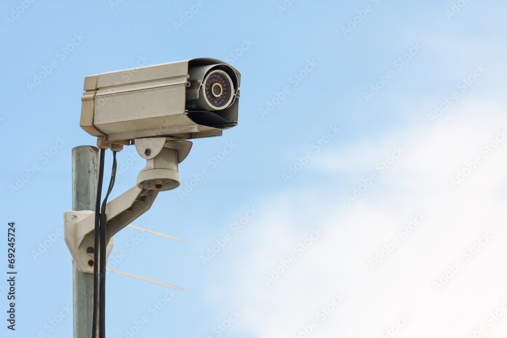 CCTV Camera or surveillance Operating with blue sky on backgroun CCTV Camera or surveillance Operating with blue sky on backgroun