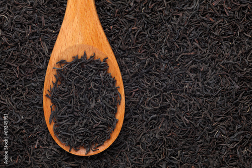 Black tea in a wooden spoon photo