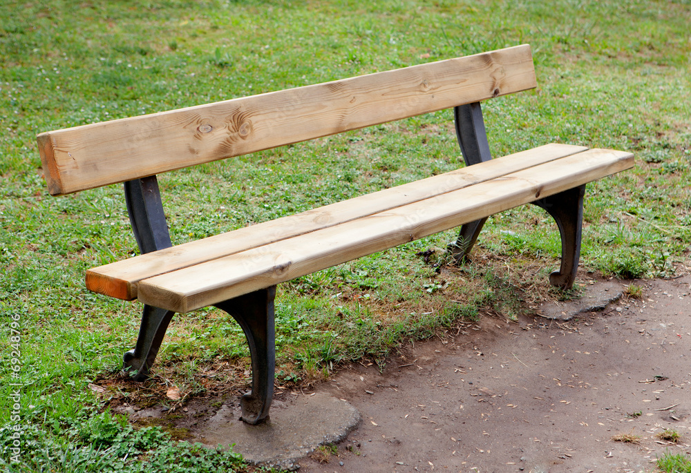 Wooden bench in the park on grass Wooden bench in the park on grass