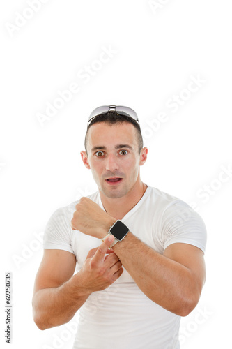 confused handsome man in white t-shirt pointing a finger at cloc