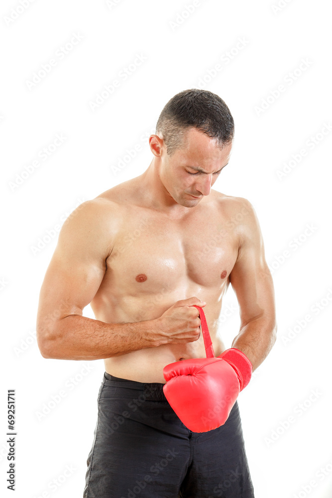 Fit man putting his boxing gloves, preparing for training over w Fit man putting his boxing gloves, preparing for training over w