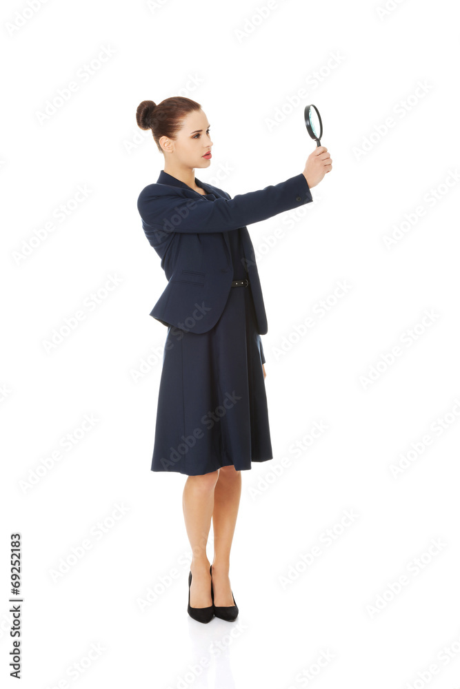 Business woman looking into a magnifying glass Business woman looking into a magnifying glass