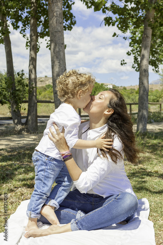mum kissing her son in the field