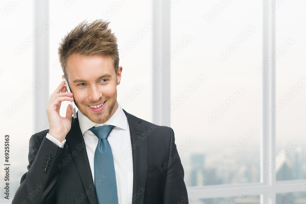 Half-length portrait of businessman speaking on cell phone Half-length portrait of businessman speaking on cell phone