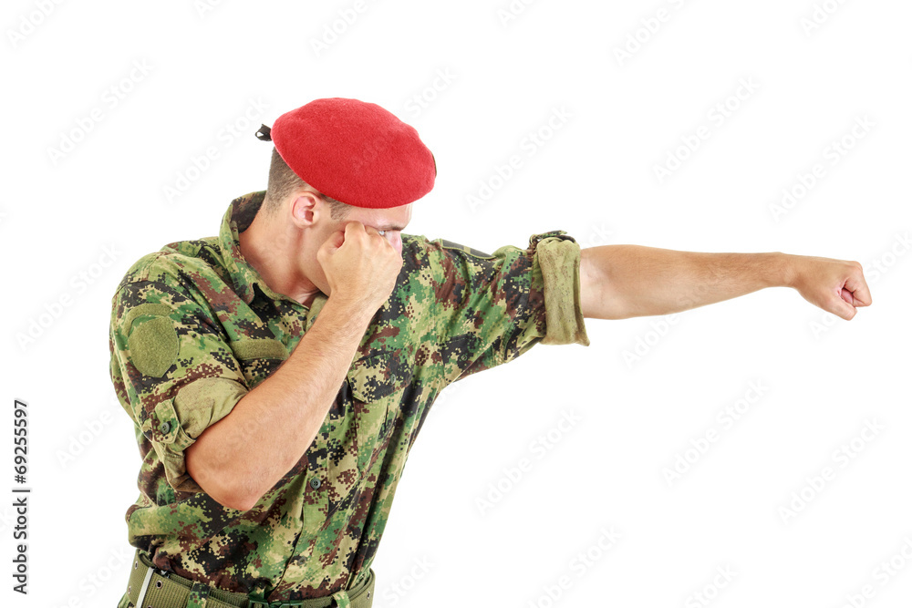 Fototapeta premium Soldier in military uniform and cap hitting with fist