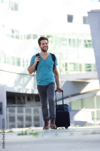 Cool guy walking with suitcase and bag