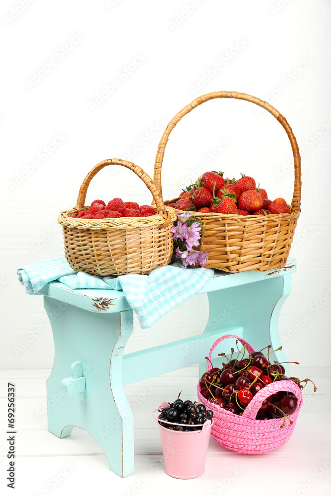 Fresh berries in baskets on white wall background Fresh berries in baskets on white wall background