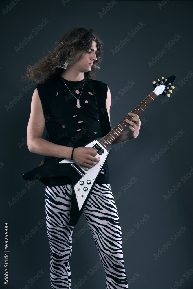 Male hard rock electric guitar musician with long hair. Studio s