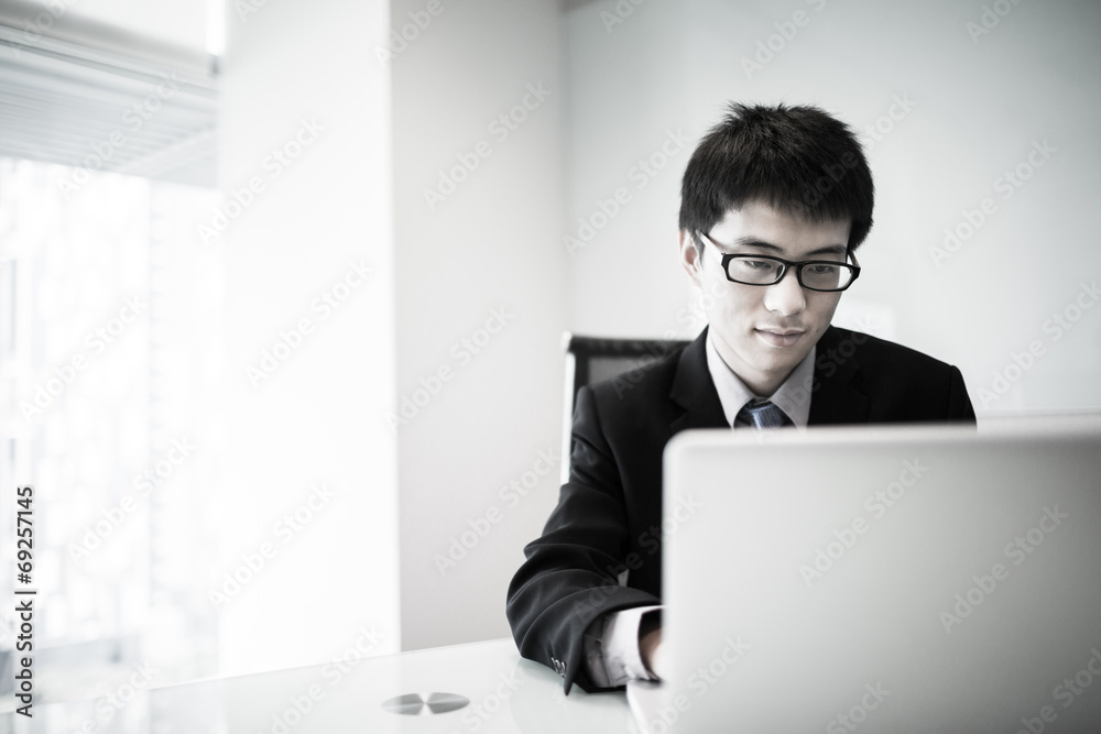 Young handsome man using laptop in his office Young handsome man using laptop in his office