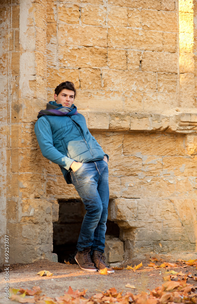 Man standing against grunge brick wall. Man standing against grunge brick wall.