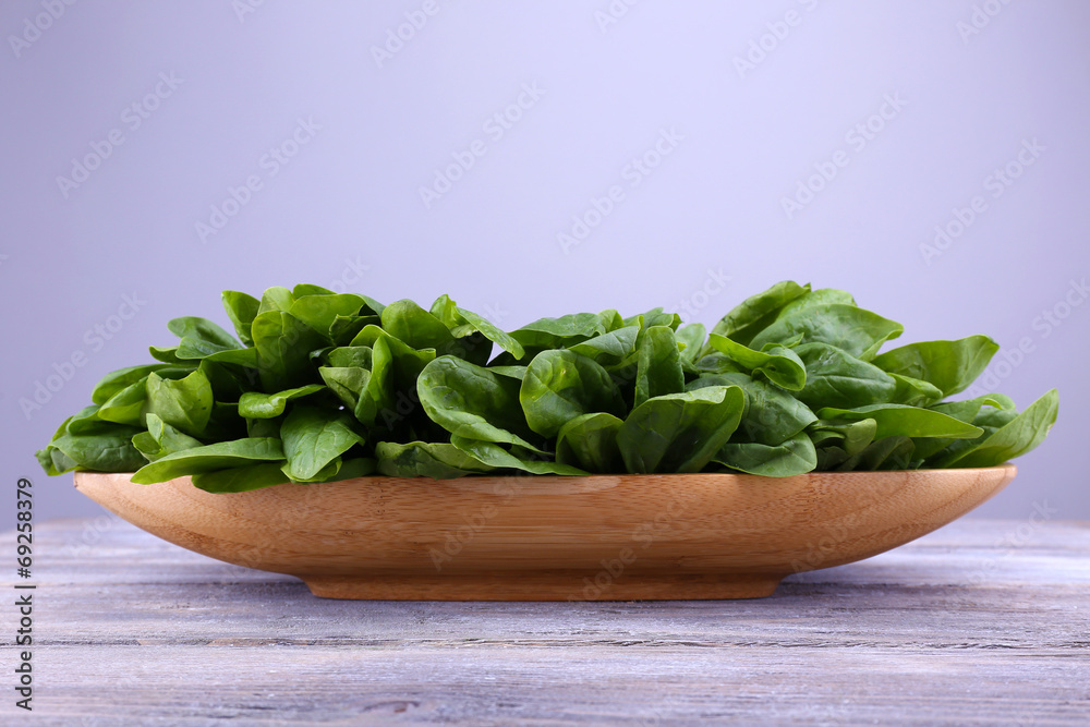 Tuft of fresh sorrel in wooden plate on wooden background Tuft of fresh sorrel in wooden plate on wooden background