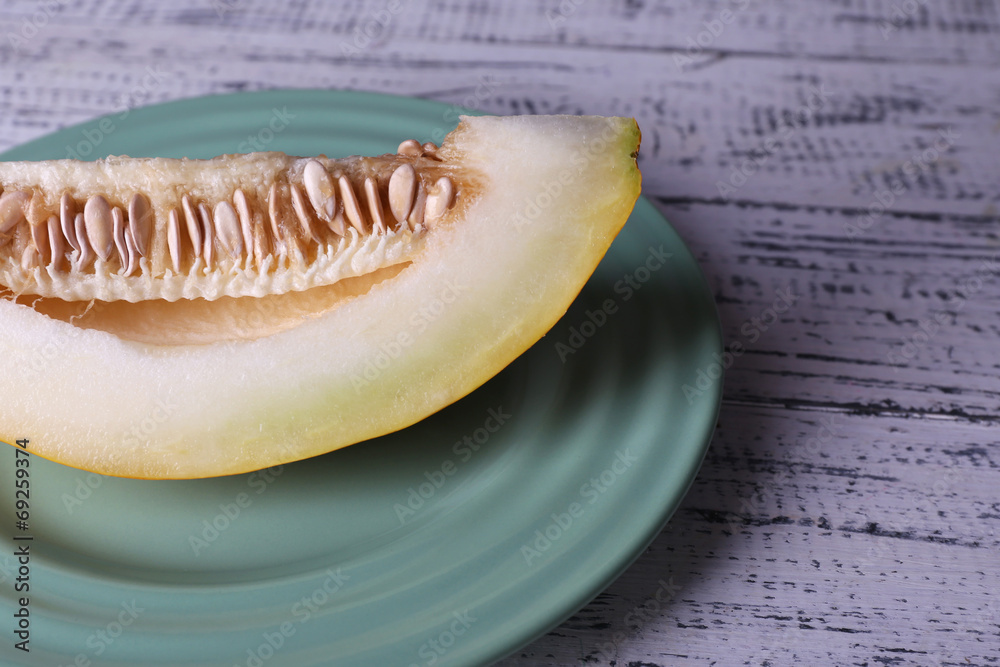 Slice of melon on plate on wooden background Slice of melon on plate on wooden background