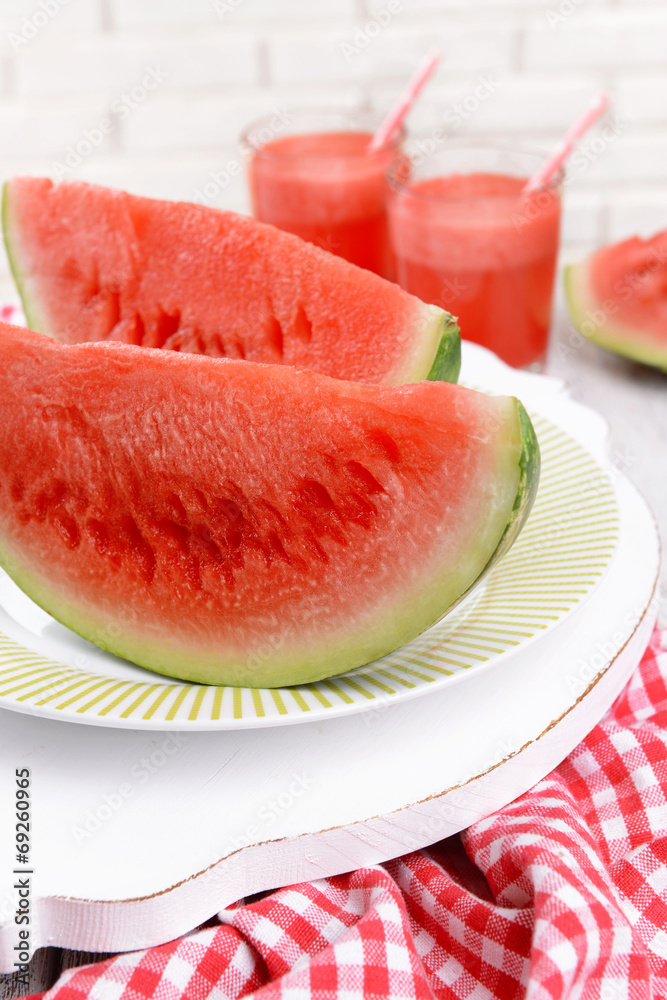 Juicy watermelon on table on brick wall background Juicy watermelon on table on brick wall background