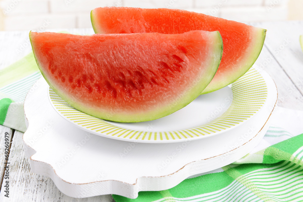 Juicy watermelon on table on brick wall background Juicy watermelon on table on brick wall background