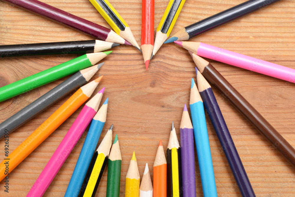 Fototapeta premium Colored pencils on wood with heart form