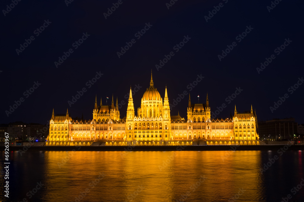 Budapest parliament building at night illuminated over the river