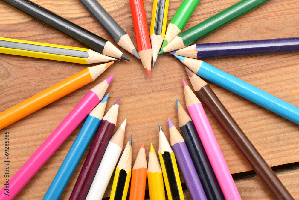 Naklejka premium Colored pencils on wood with heart form