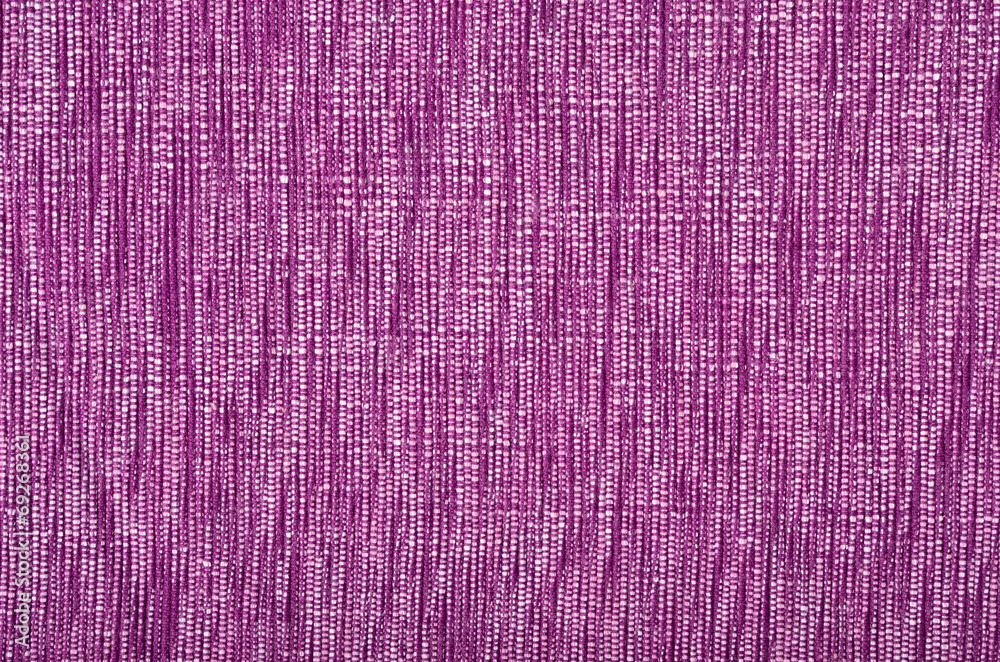 Purple material as background. Pink woven with threads pattern.