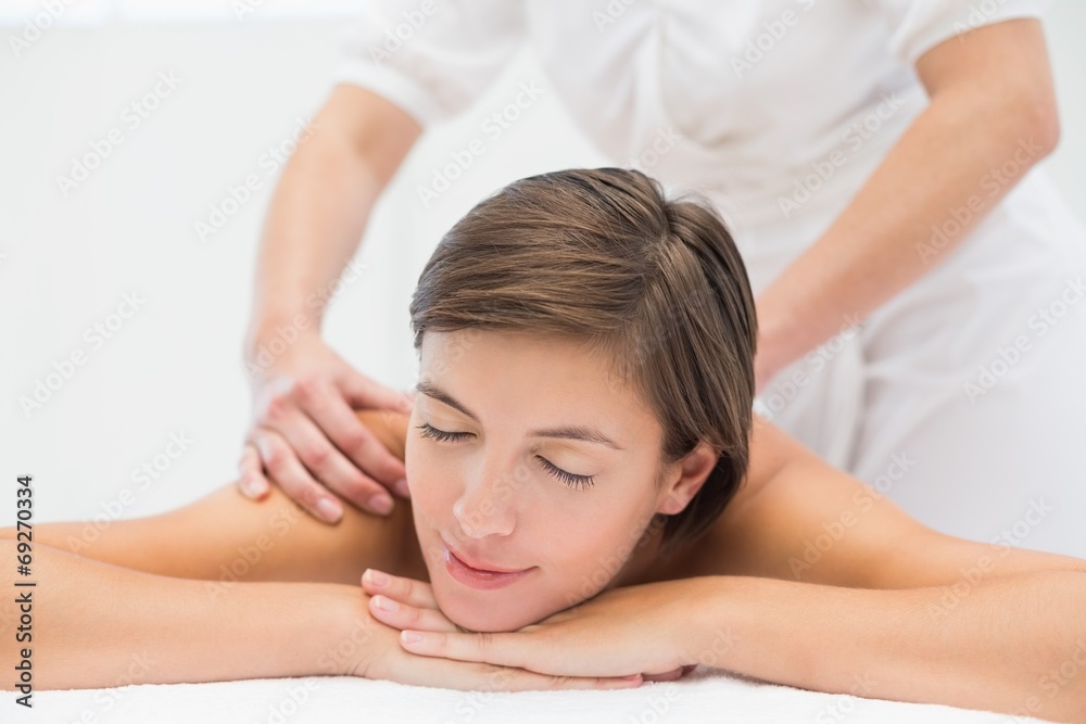 Attractive young woman receiving shoulder massage at spa center Attractive young woman receiving shoulder massage at spa center
