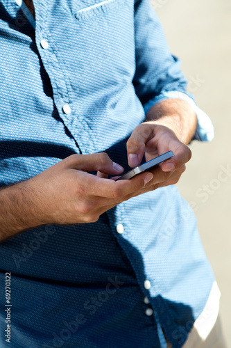 Young man using mobile phone in the street.